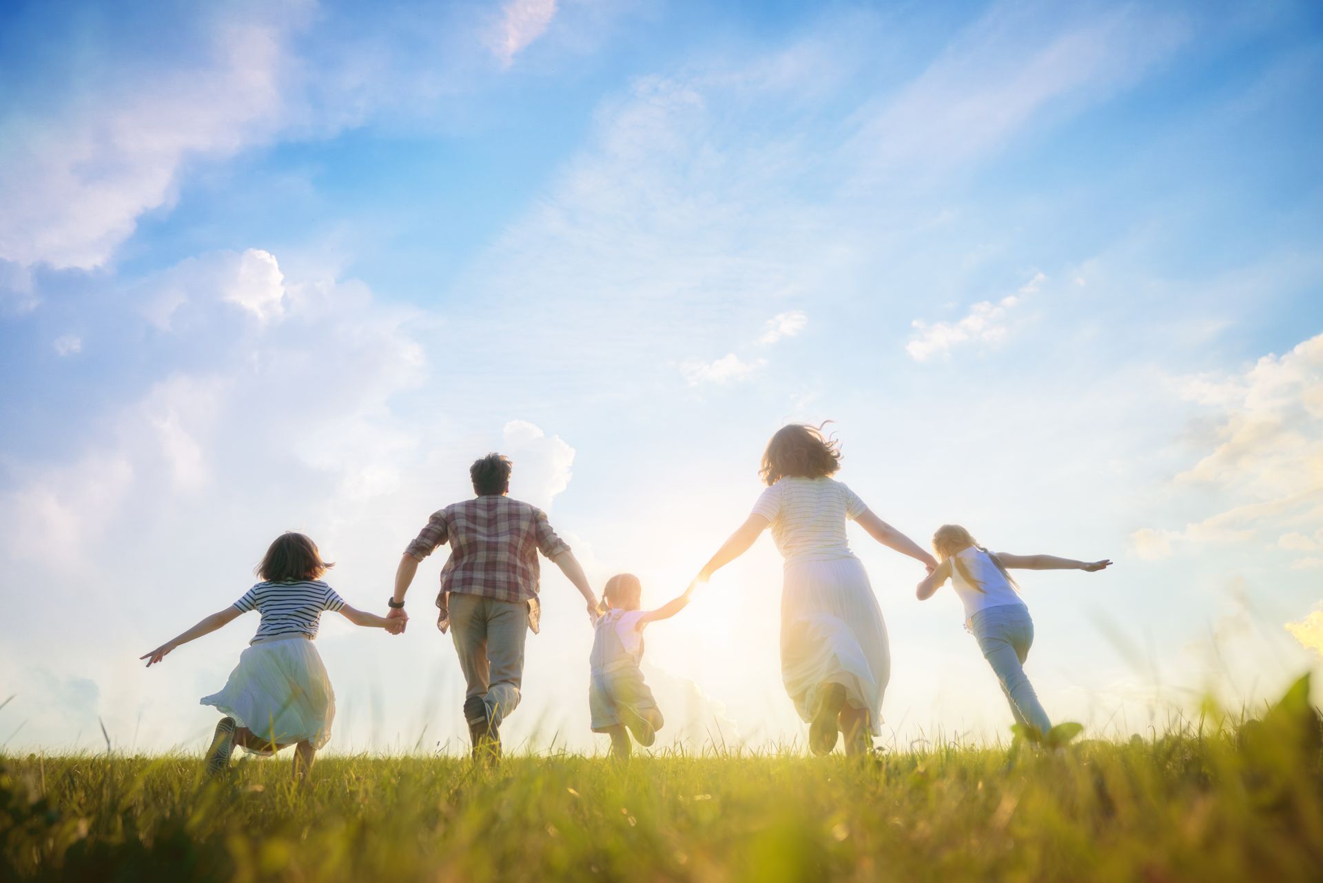 Happy family on summer walk! Mother, father and daughters walking in the Park and enjoying the beautiful nature.